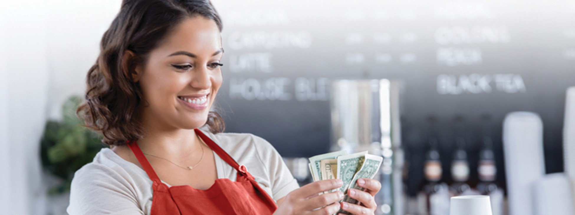 Young woman in an apron counting money