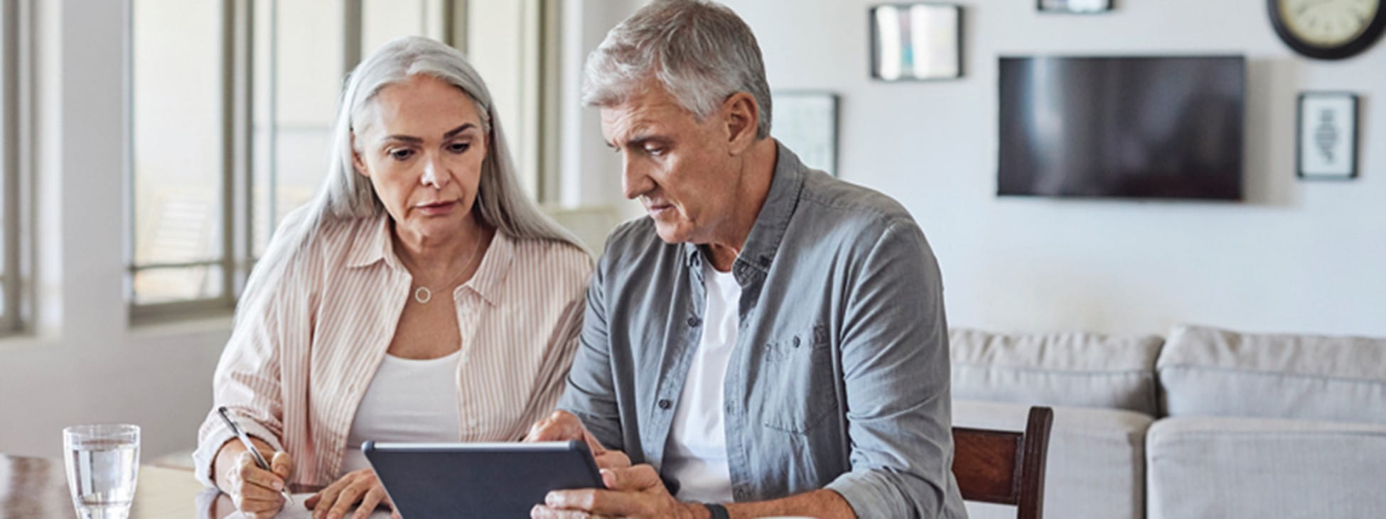 older man and woman looking at a tablet