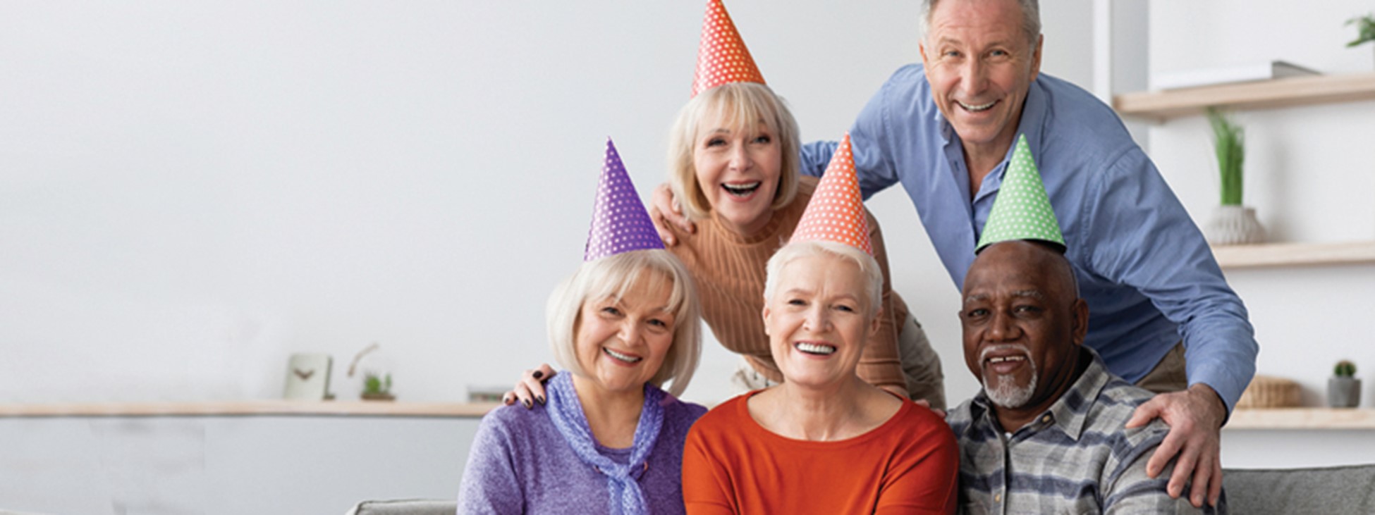 A group of older adults with wearing birthday cone hats