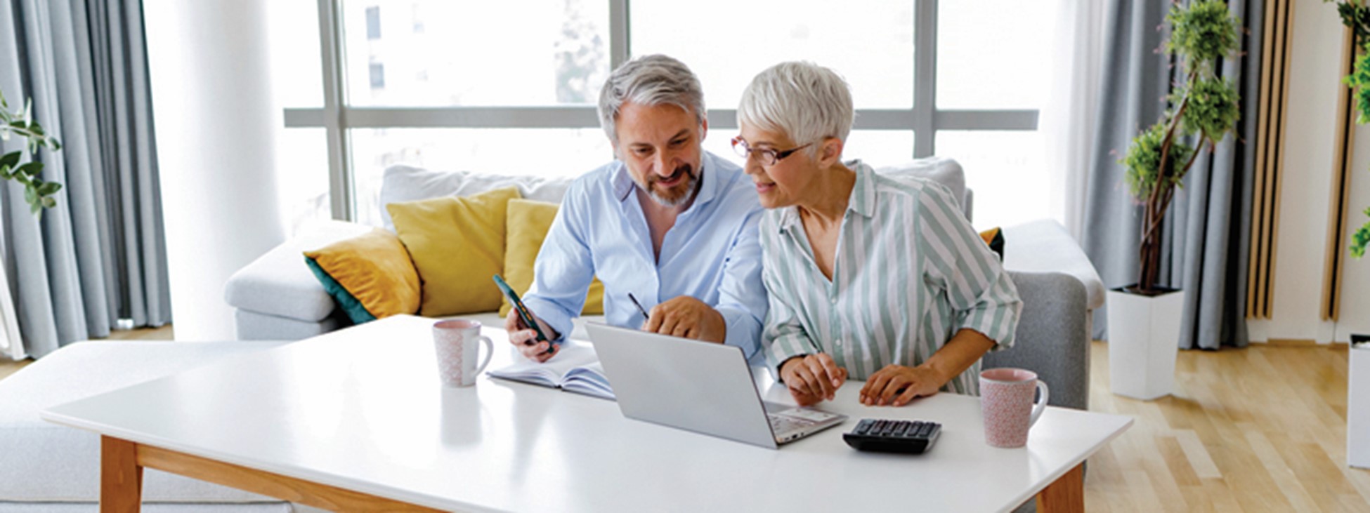 Mature couple reviewing documents and their laptop