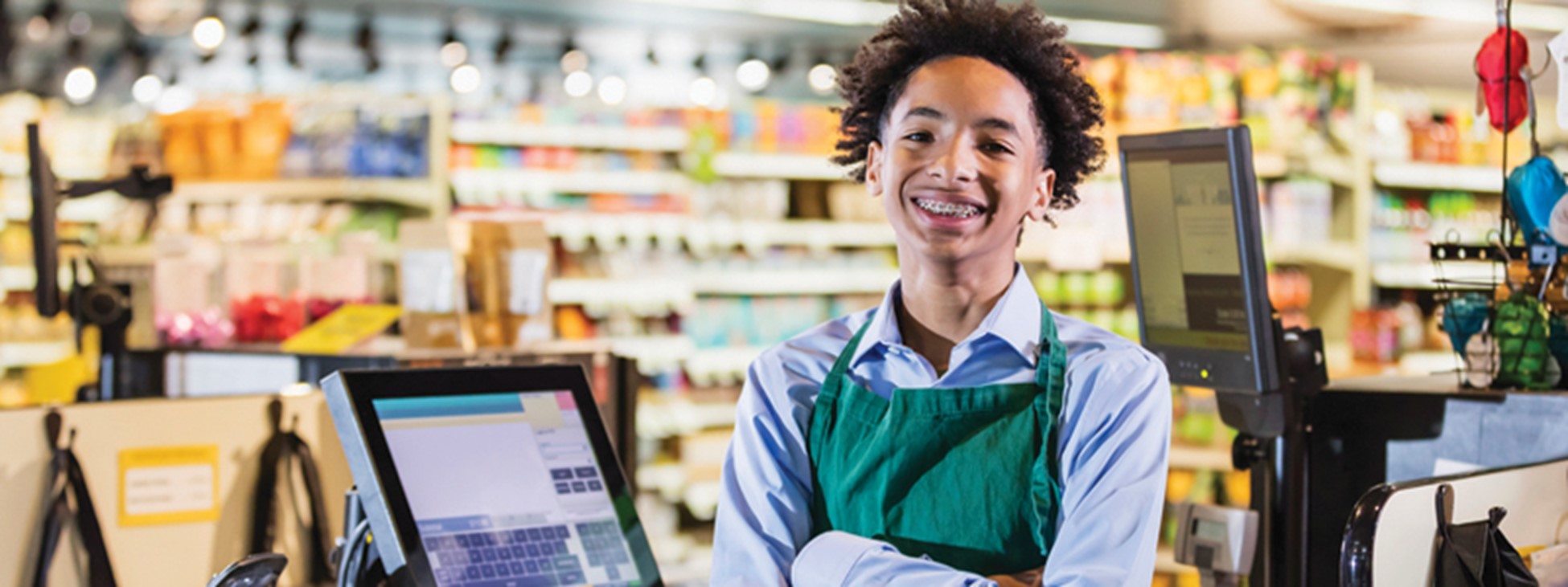 young man behind cashier counter at grocery store