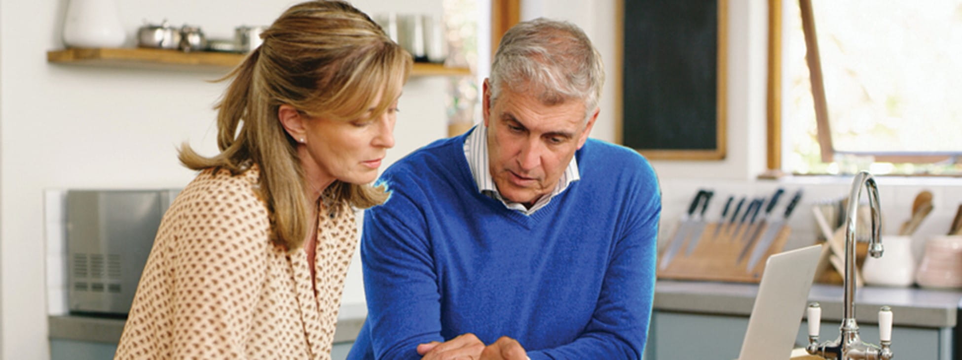 A woman and man looking at something on the computer