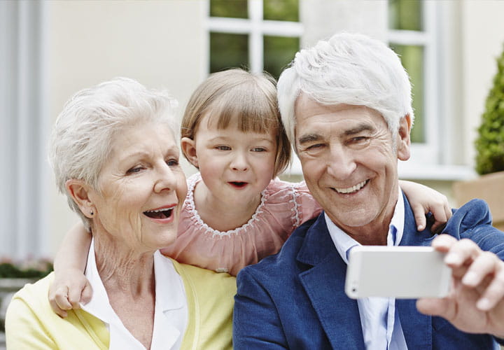 Grandparents playing with boy on slide